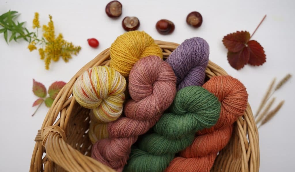 basket full of colourful skeins of naturally dyed yarns