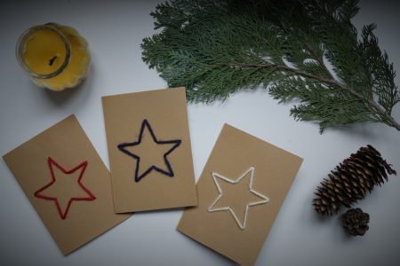 three cardboard cards with a star embroidered on them