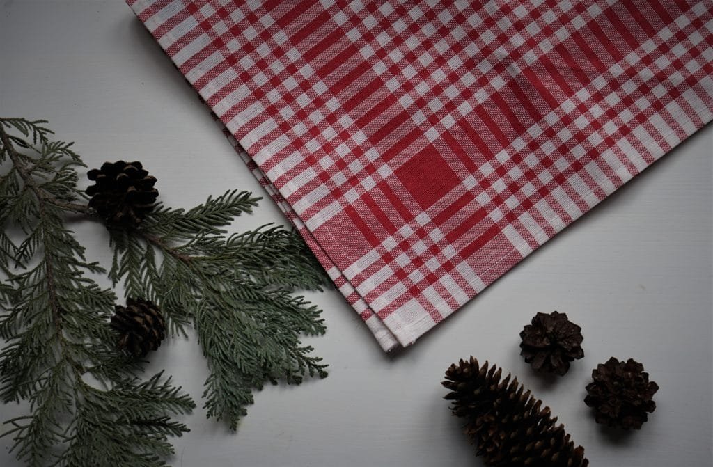 red and white dishcloth, a branch and some pine cones