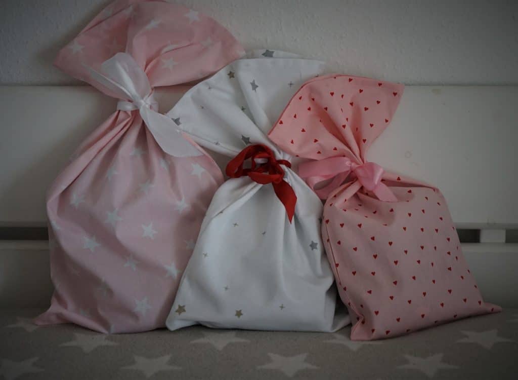 three fabric bags in white and pink, tied with a ribbon