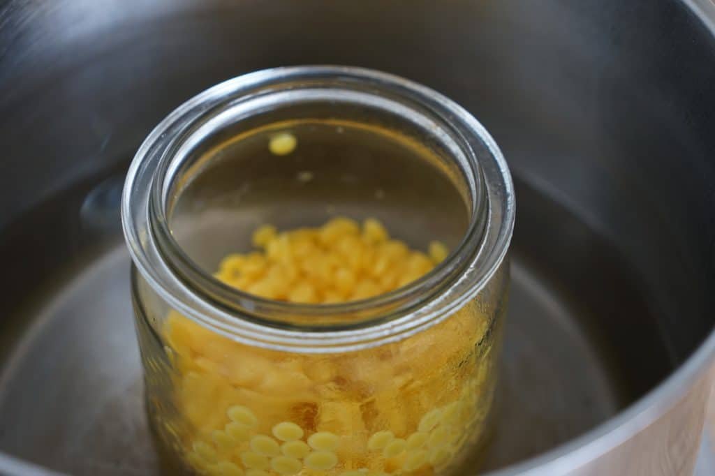 beeswax melting in a glass jar on a water bath