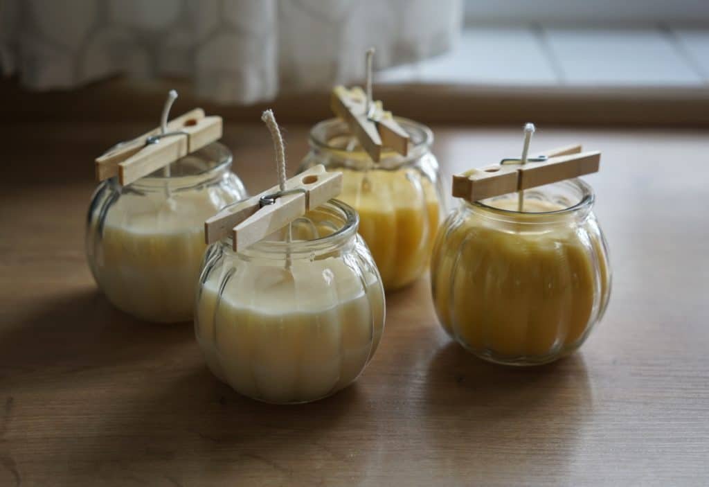 four freshly poured candles with wicks