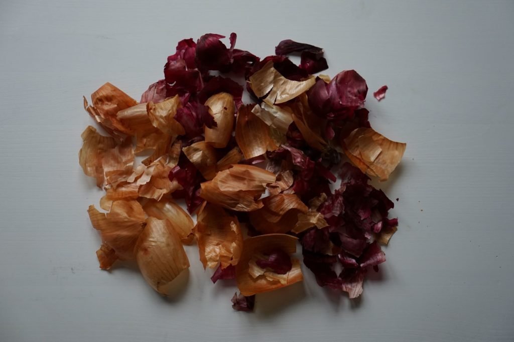 pile of red and yellow onion skins on a white background