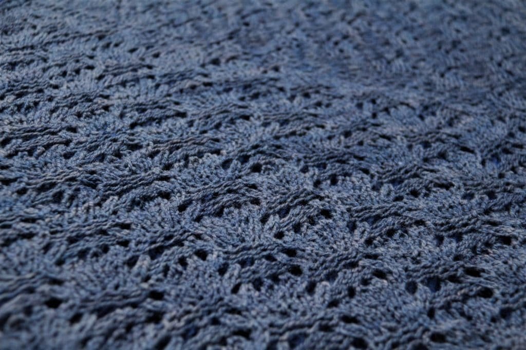 rosemary & pines fiber arts merino sport yarn knitted into a dark blue lace shawl