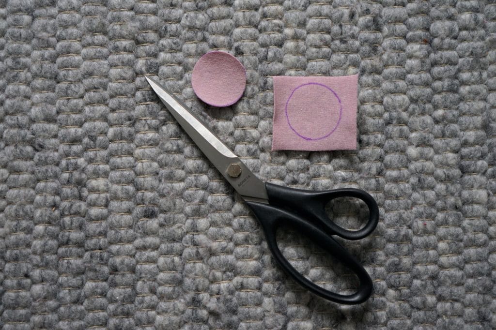 pink piece of scrap fabric, a pink circle and a pair of scissors