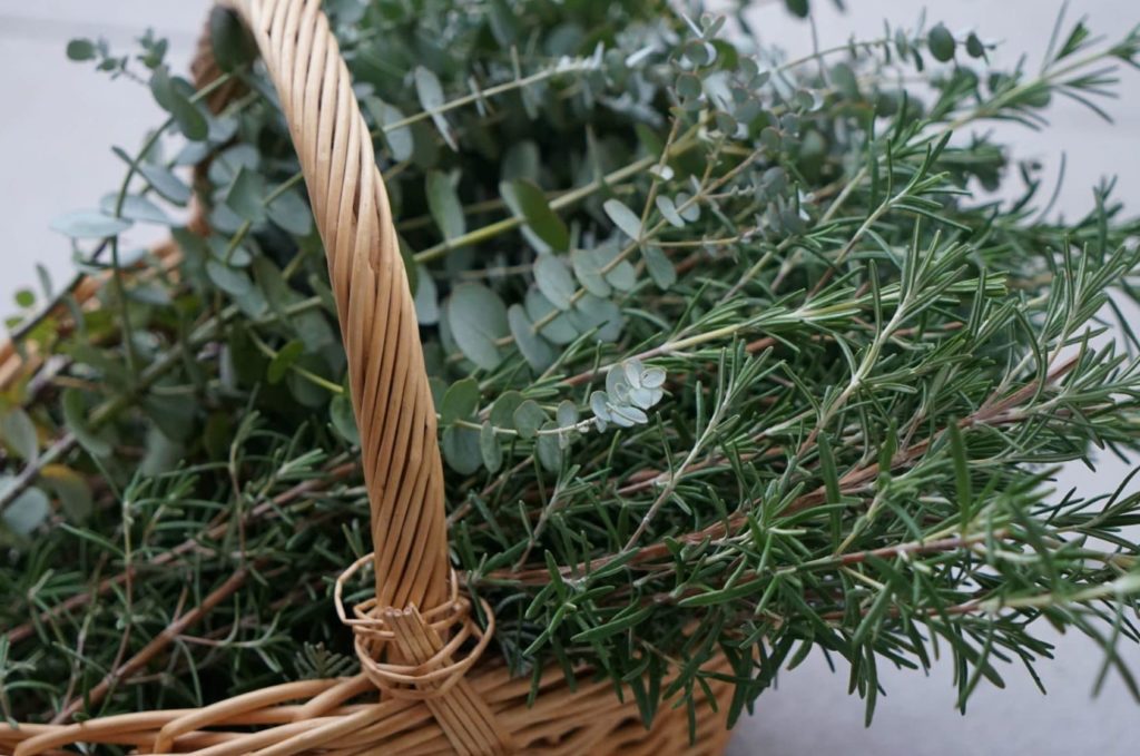 rosemary and eucalyptus branches in a wooden basket