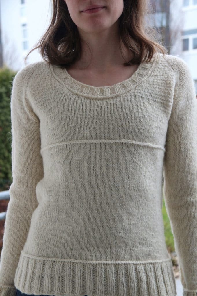 a woman wearing a cream coloured sweater (test knitter for making stories)