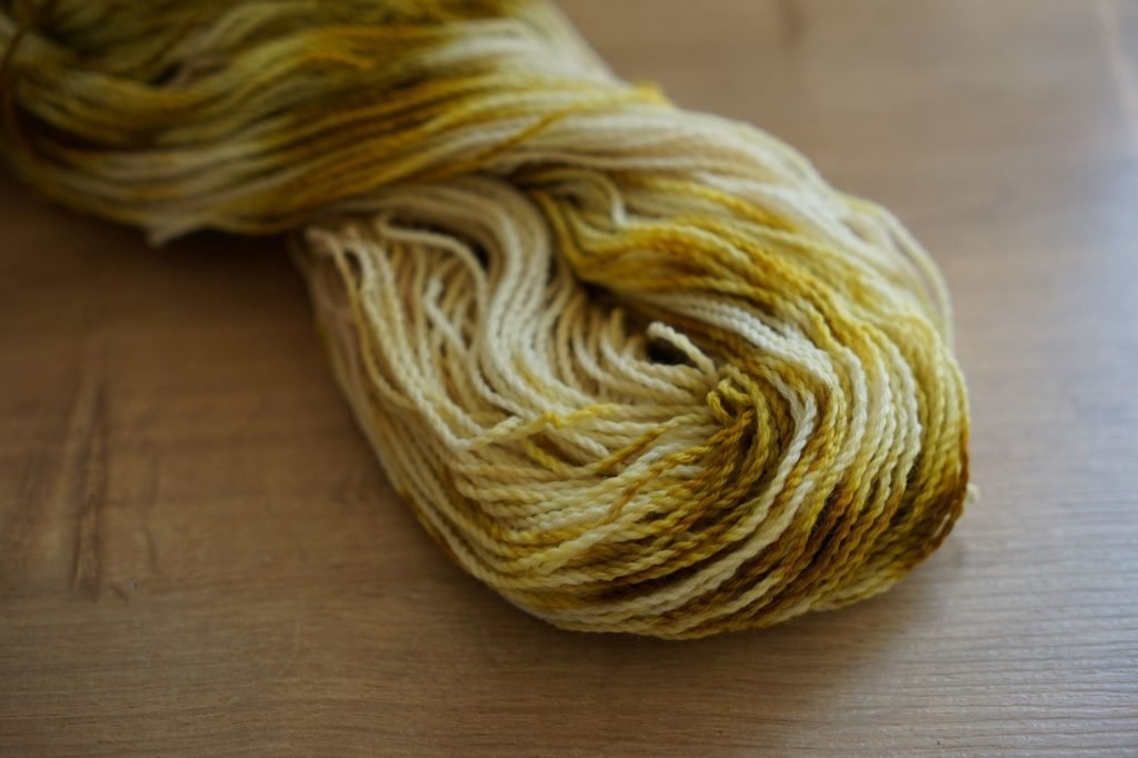 green, white and yellow hank of yarn naturally dyed with red onion skins