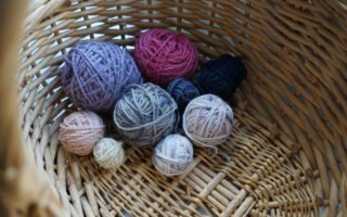 little balls of yarn for sock yarn scrappy projects sitting in a wooden basket