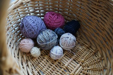 little balls of yarn for sock yarn scrappy projects sitting in a wooden basket