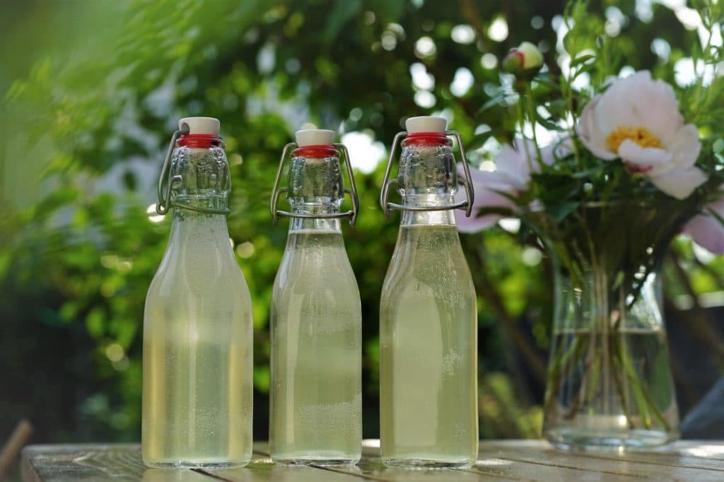 three glass bottles of homemade elderflower cordial