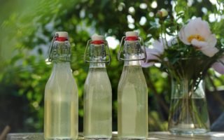 three glass bottles of homemade elderflower cordial