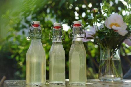 three glass bottles of homemade elderflower cordial