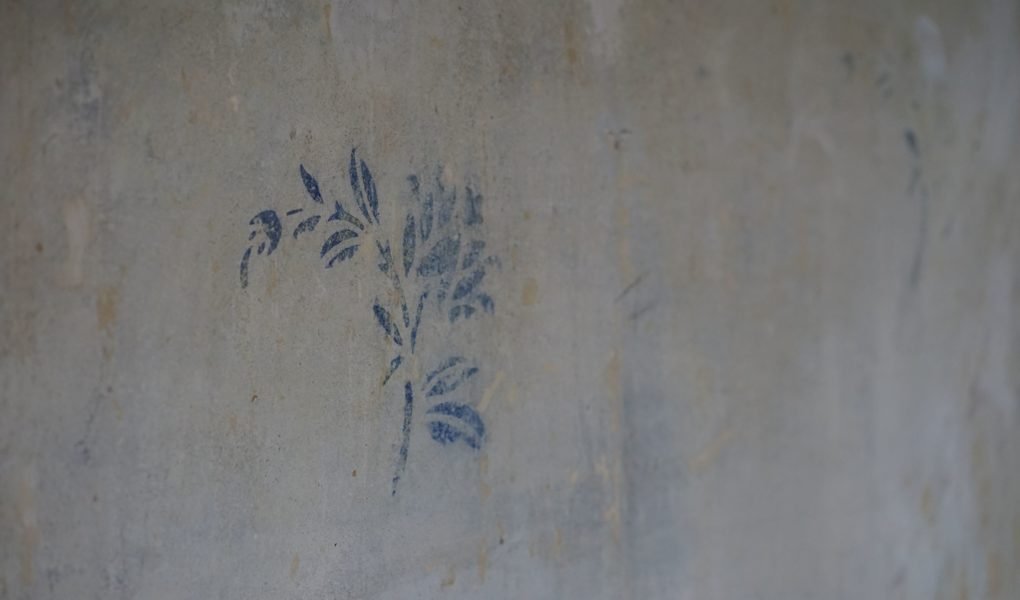 blue flower pattern on a concrete wall
