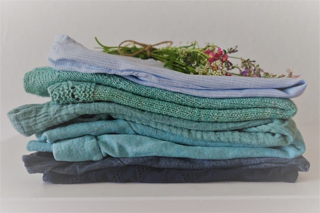 stack of handmade clothes and a wildflower bouquet