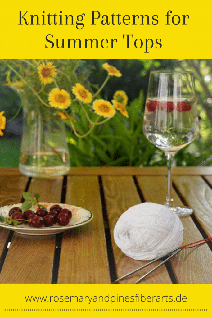 wooden table with cocktail, cherries, a wildflower bouqet and a white yarn and knitting needles on it