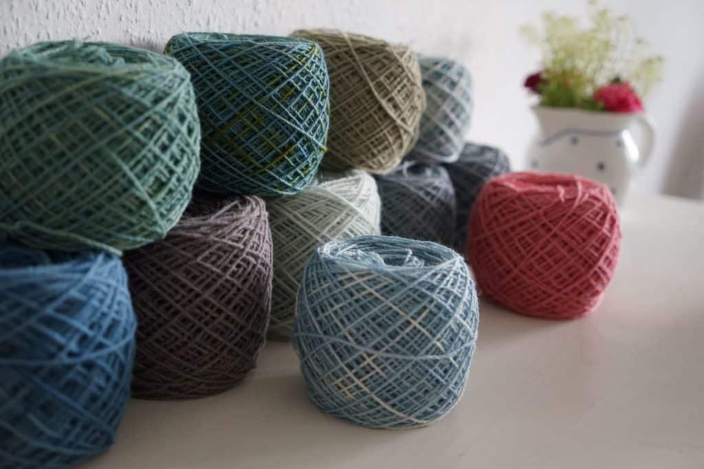 several cakes of naturally dyed yarns in blue and pink tones