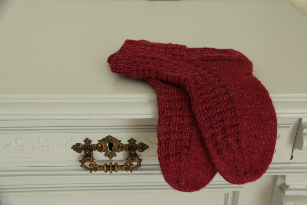 a pair of red/pink blueberry waffle socks on a grey dresser