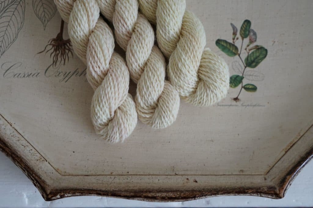 three pale yellow skeins of yarn naturally dyed with tansy