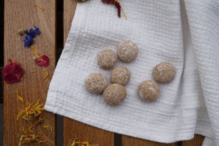 diy aroma stones on a white kitchen towel on a wooden table next to some colourful dried flowers