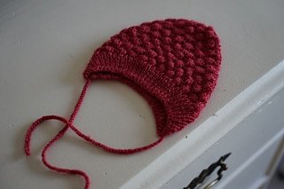 red bobble hat in a newborn size