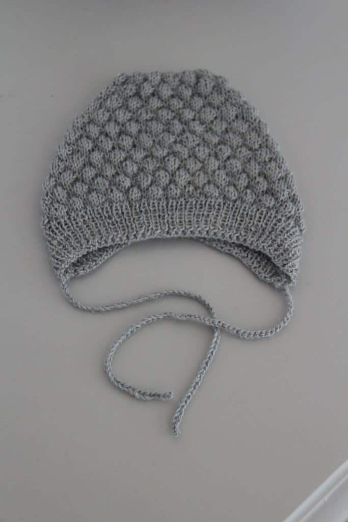 grey bobble hat on a grey dresser