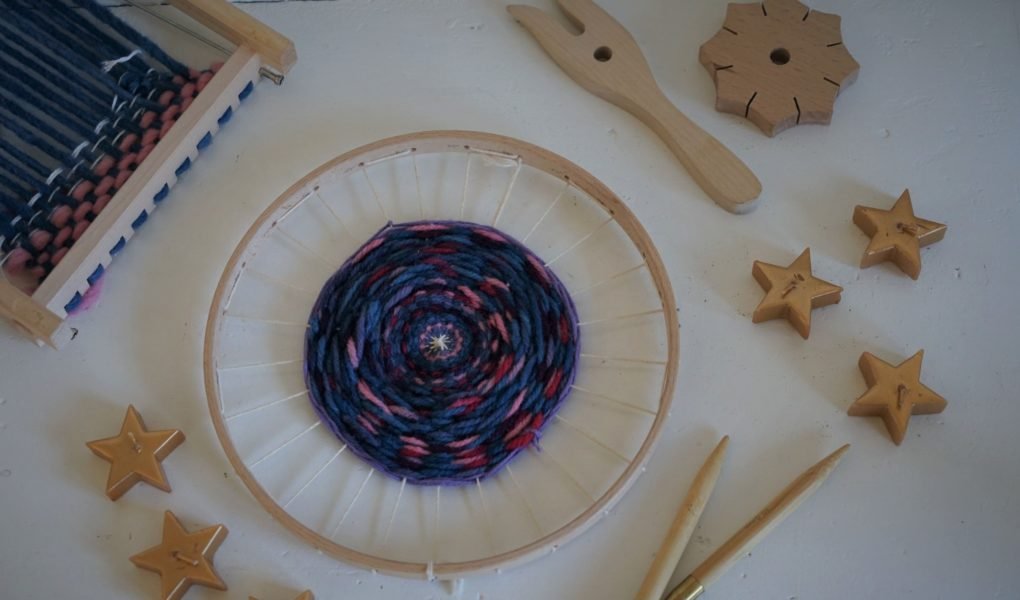 weaving loom, knitting fork, knitting needle and a knotting star along with some golden star shaped candles