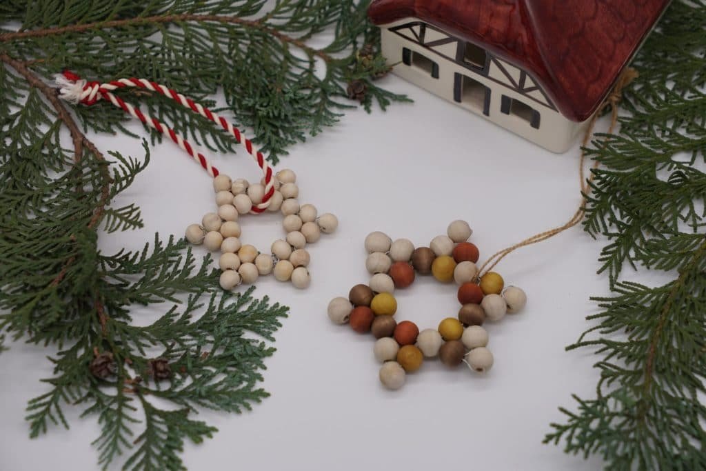 wooden beads star ornaments, a ceramic house and some branches