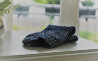 blue sock on a grey dresser and some flowers in a vase