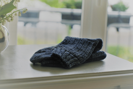 blue sock on a grey dresser and some flowers in a vase