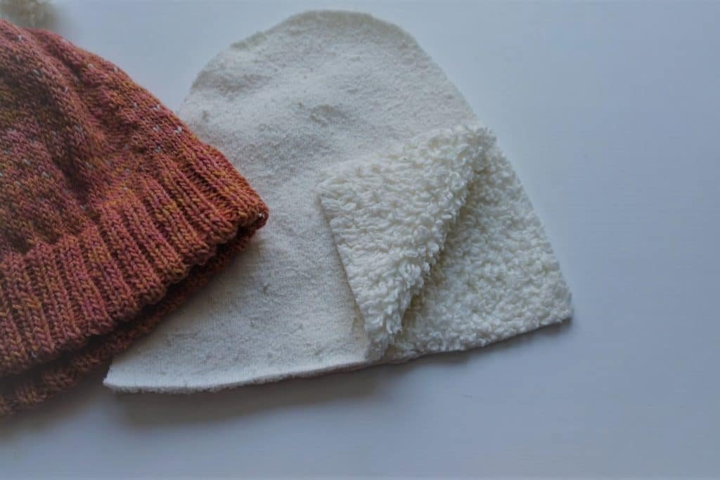 cutting out two pieces of lining for a knitted hat