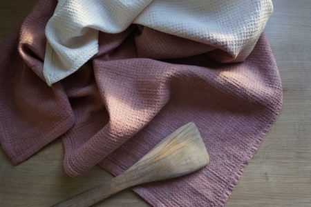 dusty pink and white linen waffle kitchen towels and a wooden spatula