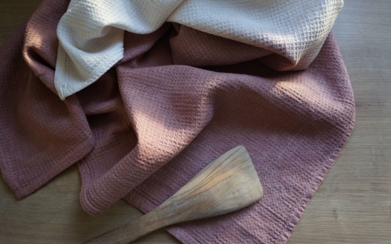 dusty pink and white linen waffle kitchen towels and a wooden spatula