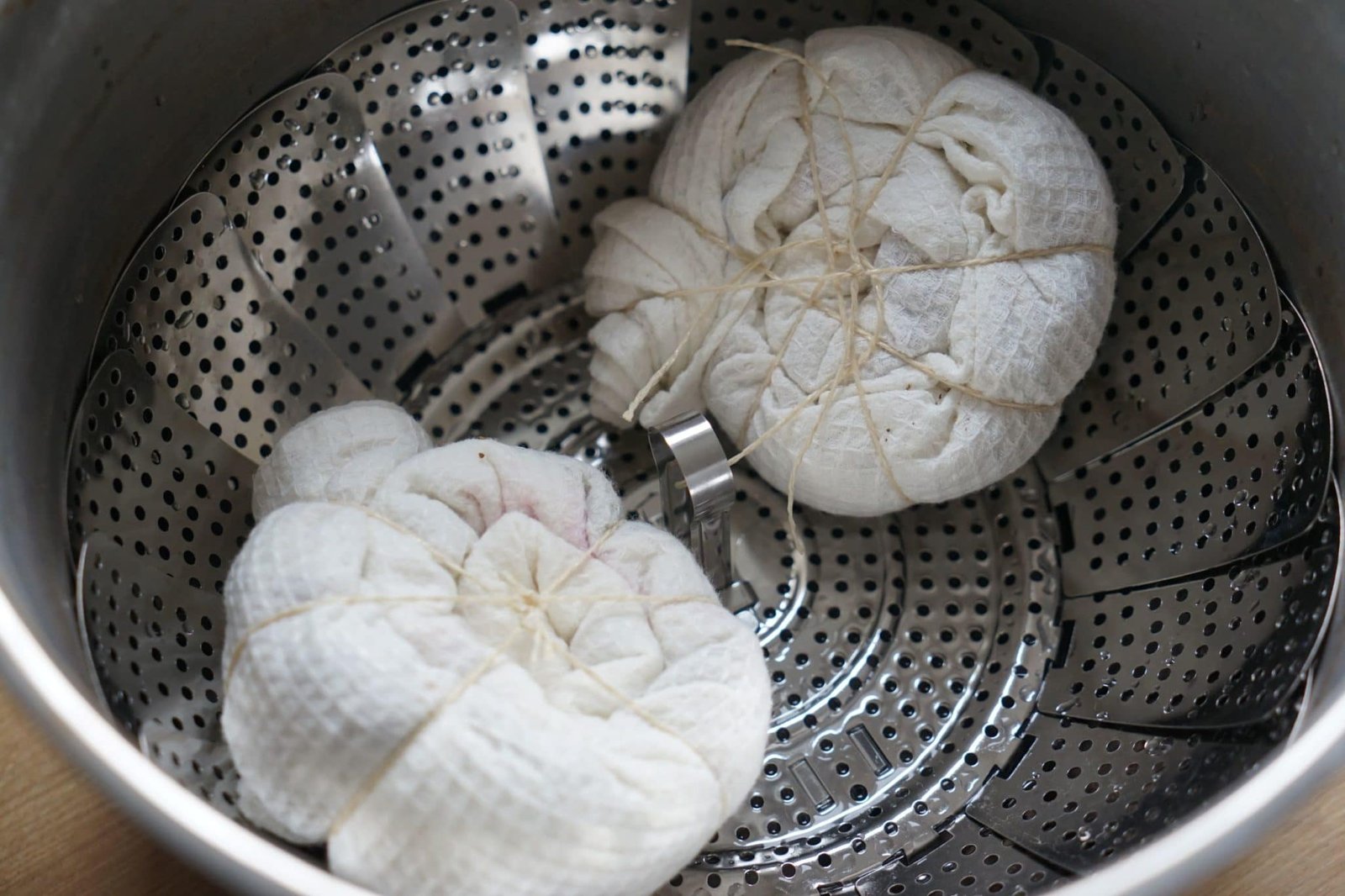 two kitchen towel bundles in the steamer basket before the natural dyeing process