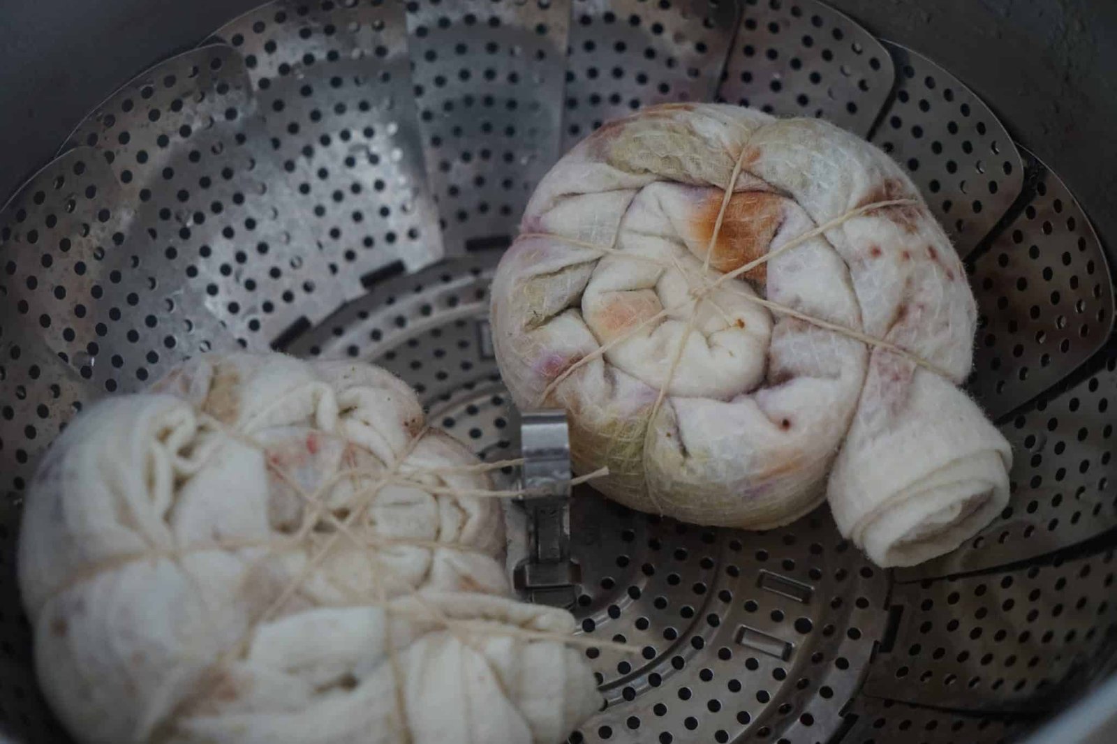two bundles of kitchen towels in the steamer basket during the natural dyeing process