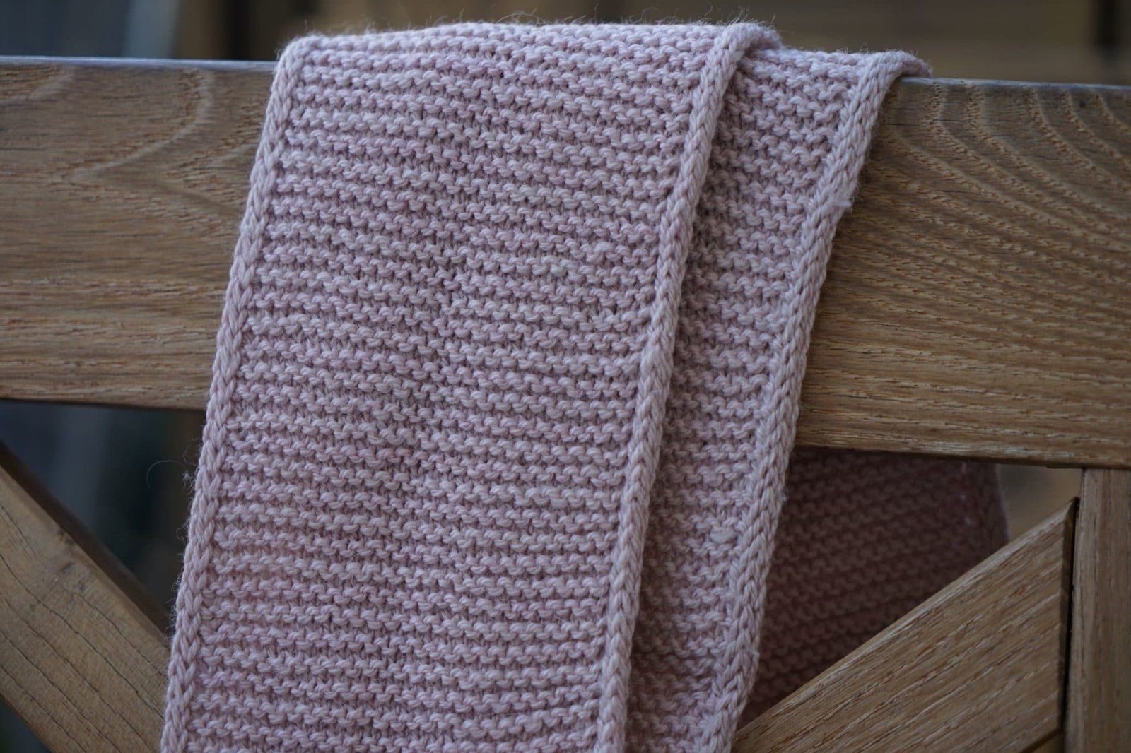 light pink circle scarf hanging over a wooden stool