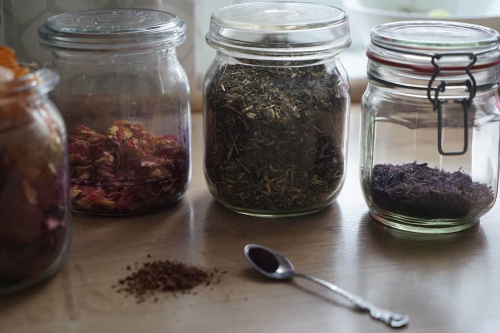 four glass jars filled with natural dyestuff