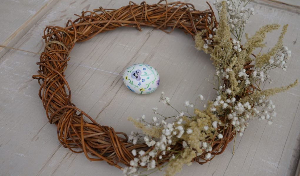 willow wreath decorated with glysophila and goldenrod and an hand painted easter egg