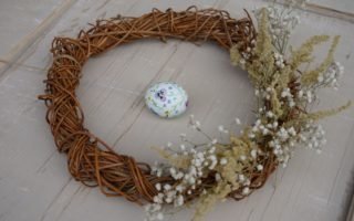 willow wreath decorated with glysophila and goldenrod and an hand painted easter egg