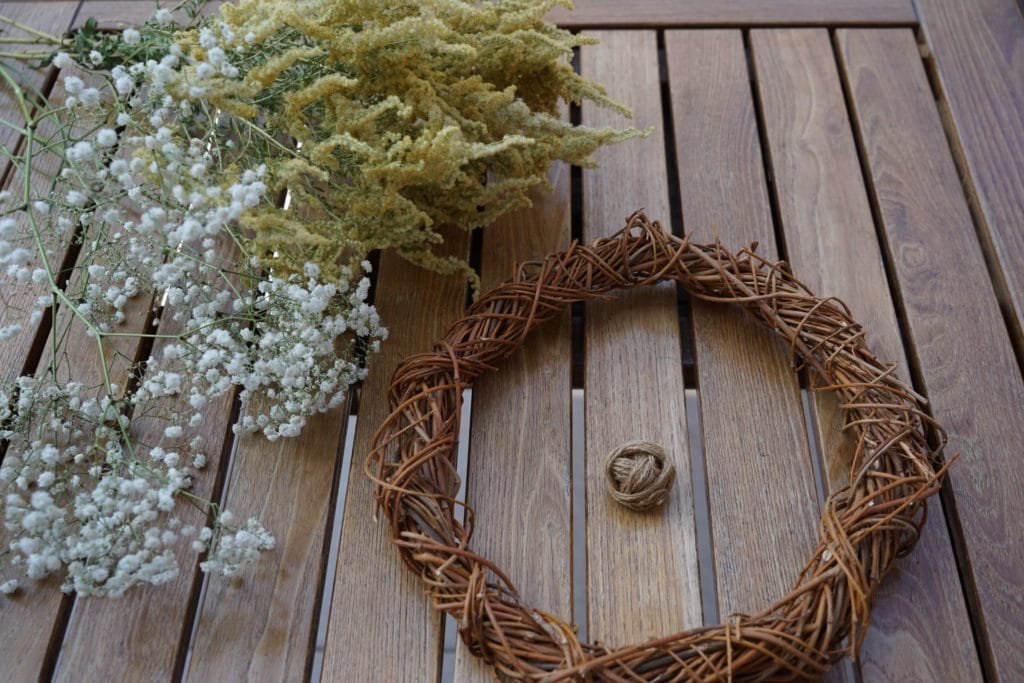 materials you need to make a diy spring wreath (willow wreath base, flowers and jute twine)