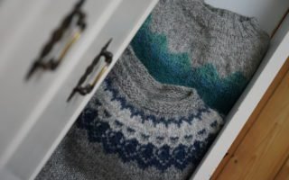 two circular yoke sweater peeking out of a white dresser