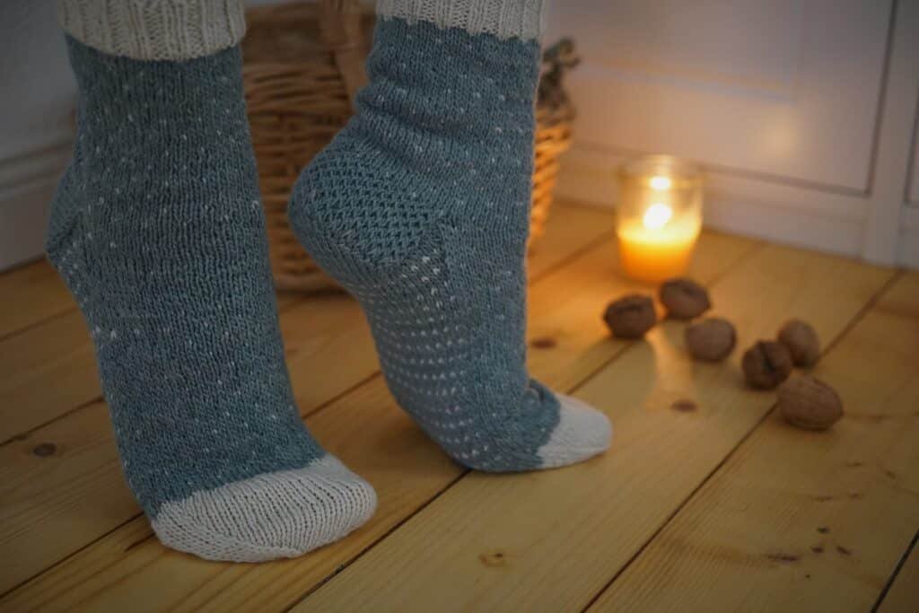 two feet standing on the toes in handknitted socks