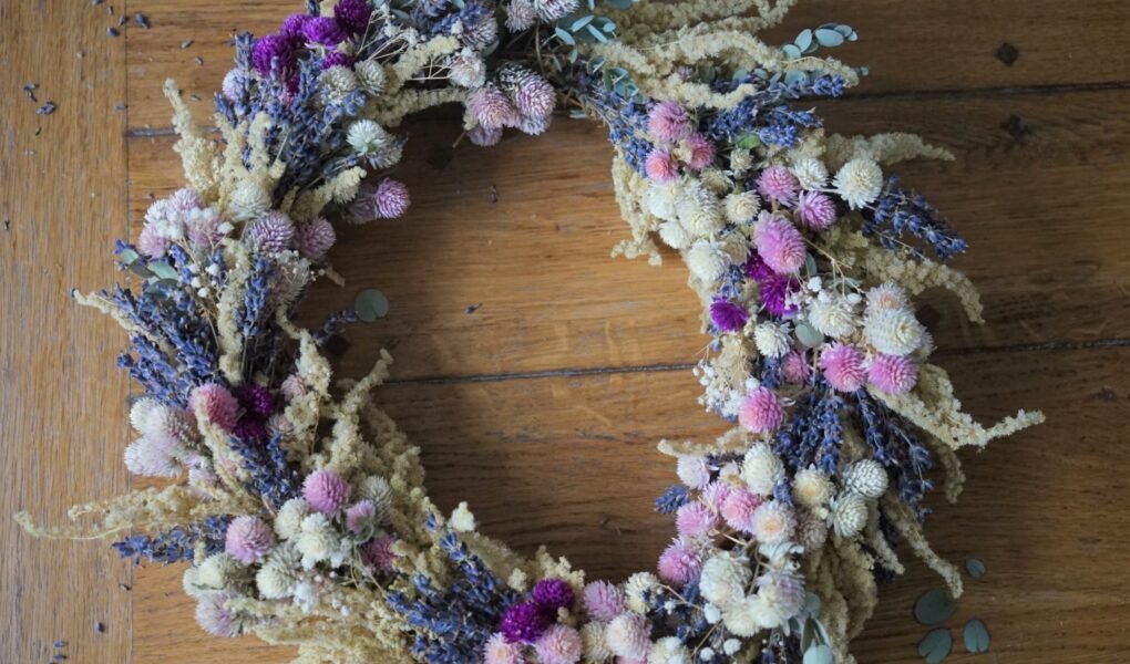 dried flower wreath in purple, pink, white and yellow on a wooden table