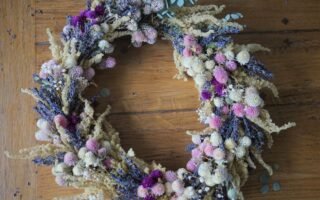 dried flower wreath in purple, pink, white and yellow on a wooden table