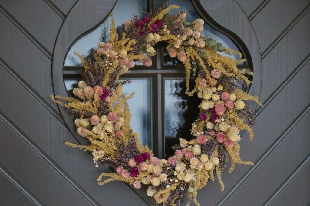 dried flower wreath hanging on a grey front door