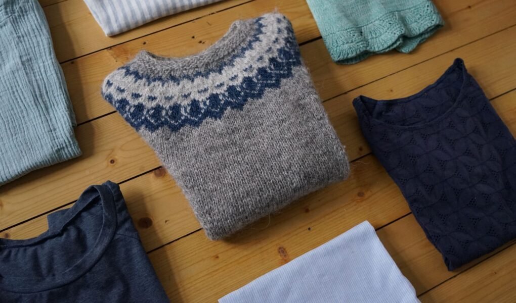 handmade garments folded and lying on a wooden floor