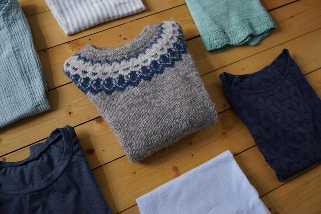 handmade garments folded and lying on a wooden floor