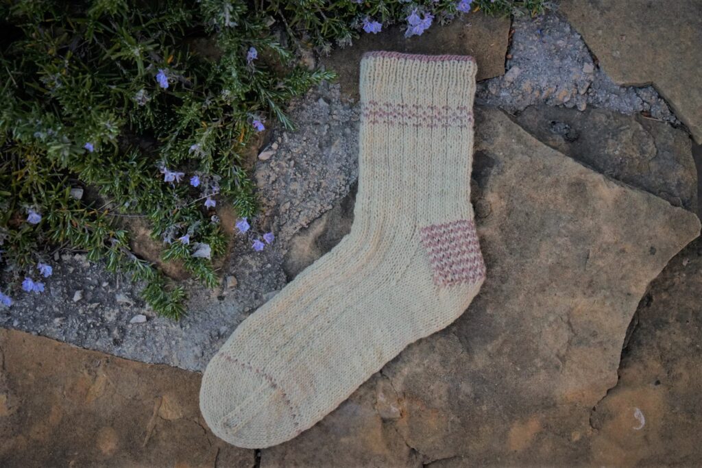 a handknitted sock on a rocky background